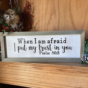 May include: A wooden sign with a white background and a gray frame. The sign reads "When I am afraid I put my trust in you Psalm 56:3".