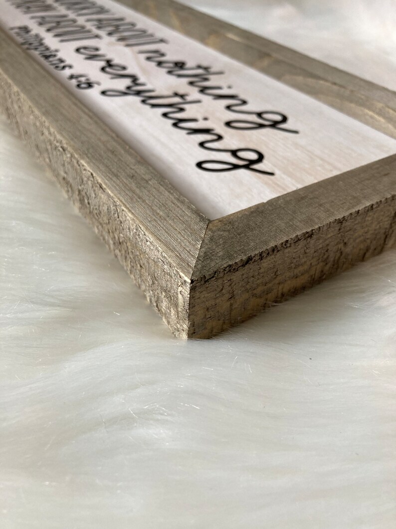 May include: A rustic wooden sign with a white background and black text that reads "Be thankful for everything and pray about nothing".
