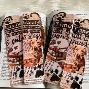 May include: Four colorful bookmarks with images of cats and dogs. The bookmarks feature the text "Easily distracted by books & cats & dogs" and "Time for a paws" with paw prints.