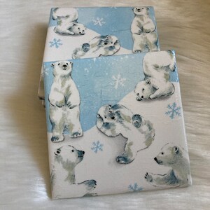 May include: Set of four square ceramic coasters featuring a white background with a blue and white pattern of polar bears in a snowy landscape.