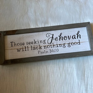 May include: A framed wood sign with a white background and black lettering. The sign reads "Those seeking Jehovah will lack nothing good Psalm 34:10".