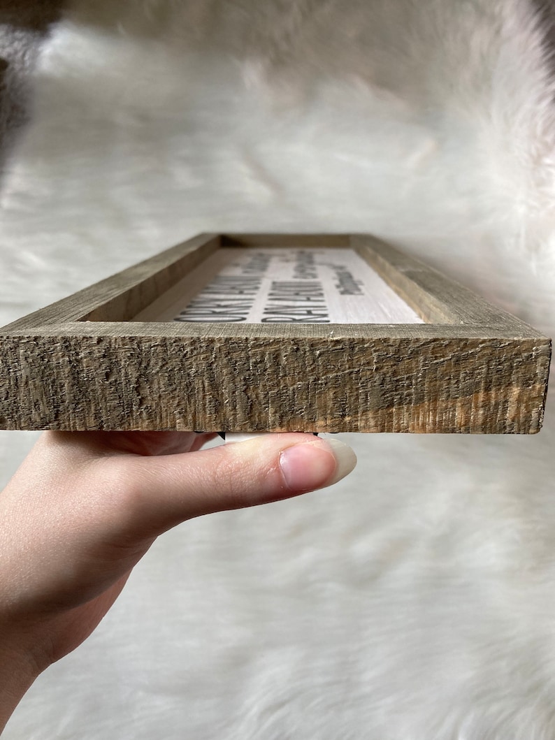 May include: A wooden sign with the text "Our family is a circle of strength and love. With every beat of our hearts, we are connected. Together we stand, together we grow, together we love."