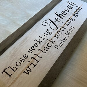 May include: A wooden sign with a gray frame and white background. The sign reads "Those seeking Jehovah will lack nothing good Psalm 34:10".