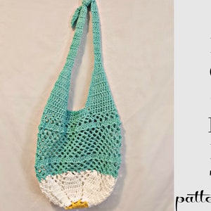May include: A crochet bag with a teal and white color scheme. The bag has a wide, open top and a single strap. The bag is made with a simple crochet stitch and has a daisy-like design at the bottom.