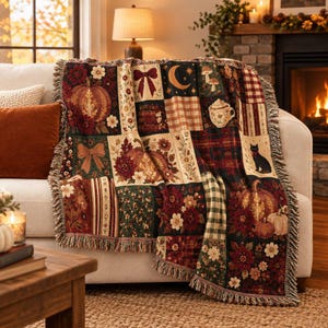 Könnte beinhalten: Eine gewebte Wohndecke mit Patchwork-Design und herbstlichen Motiven wie Kürbissen, einer schwarzen Katze, Pilzen, einer Mondsichel, Schleifen, Blumenmustern und Karos in den Farben Burgunderrot, Creme, Grün und Braun.