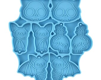 Puede incluir: Un molde de silicona azul con ocho formas diferentes de temática de Halloween, incluyendo murciélagos, calaveras y flores. El molde está diseñado para hacer manualidades de resina.
