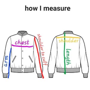 May include: Diagram illustrating how to measure a jacket. The image shows a white jacket from the front and back, with colored lines and text indicating measurement points such as chest, arm, shoulder to cuff, shoulder, and length.