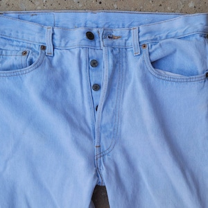 Könnte beinhalten: Hellblaue Jeans aus Denim mit Knopfleiste und fünf Taschen.