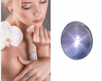 Könnte beinhalten: Ein loser, oval geformter blauer Sternsaphir-Edelstein mit einem ausgeprägten sechsstrahligen Asterismus-Effekt auf seiner glatten, polierten Cabochon-Oberfläche. Der Stein zeigt einen durchscheinenden, tiefen, immergrünblauen Farbton mit sichtbaren natürlichen Einschlüssen.