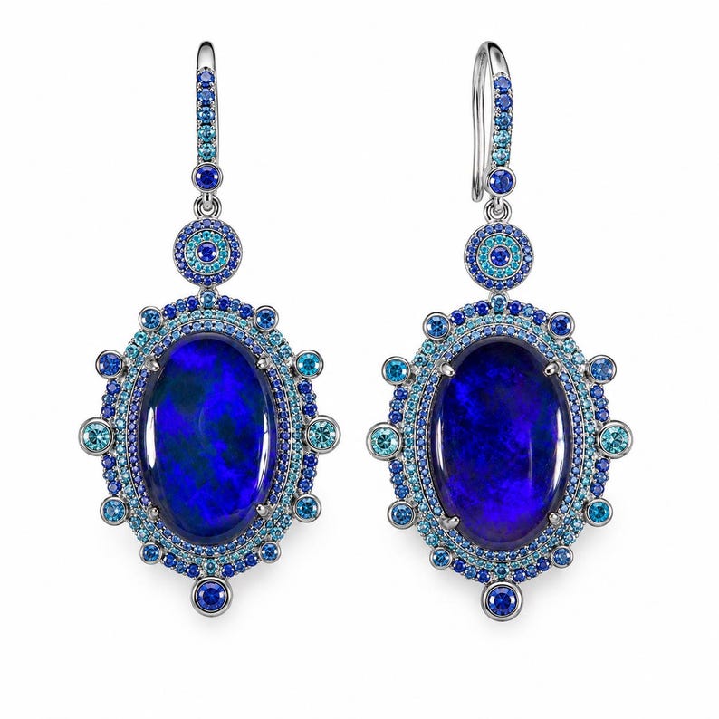 May include: A pair of ornate earrings featuring large, oval-shaped, dark blue opals. The opals are surrounded by a halo of smaller blue and turquoise gemstones, with additional accents and a silver hook.