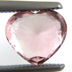 May include: A heart-shaped, light pink gemstone with a faceted cut.