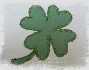 May include: A green four-leaf clover patch with a stem, stitched with green thread. The clover is centered on a white background. The text "©2016 BA St John" and "www.AnnesEmbroidery.etsy.com" are in the lower right corner.