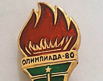 Spilla vintage delle Olimpiadi di Mosca del 1980, con design a torcia e anelli.
