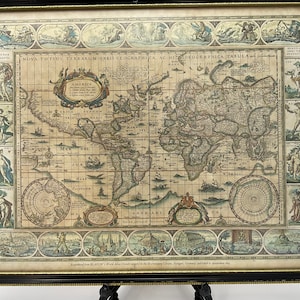 May include: A framed antique world map with a detailed illustration of the continents and oceans. The map is surrounded by a decorative border with images of people and animals. The text "NOVA TOTIUS TERRARUM ORBIS GEOGRAPHICA AC HYDROGRAPHICA TABULA" is printed at the top of the map.