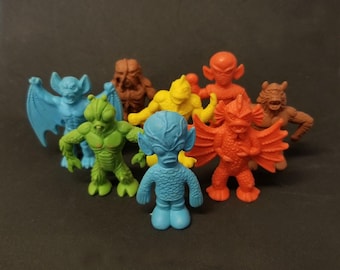 May include: A set of eight colorful rubber monster figurines. The monsters are in various poses and have different features, including wings, horns, and claws. The figurines are made of a soft, pliable rubber and are perfect for imaginative play.