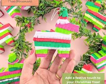 May include: Miniature piñata tree ornament in the shape of a donkey, crafted from colorful paper strips in pink, green, red, and white. The ornament has a white string for hanging. The text on the image says "Mini Piñata Tree Ornament".