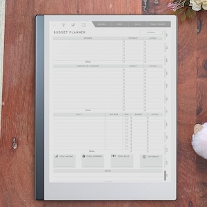 May include: A digital budget planner tablet with a light gray screen displaying financial tracking templates. The interface includes sections for incomes, expenses by category, bills, and totals, with months listed vertically along the right side.