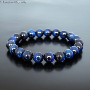Peut inclure: Un bracelet en perles d'œil de tigre bleu. Les perles sont rondes et de couleur bleu foncé avec un léger chatoiement.