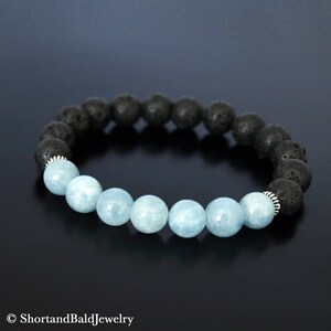 May include: A bracelet made with black lava rock beads and light blue aquamarine beads. The bracelet has silver spacers between the beads.