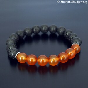 May include: A bracelet made with black lava rock beads and orange carnelian beads. The bracelet has silver spacer beads.