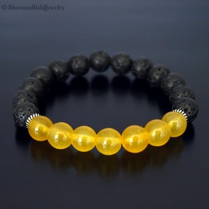 May include: A black lava rock and yellow jade beaded bracelet. The bracelet has silver spacer beads.
