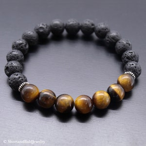 Op de afbeelding: Een armband met zwarte lavastenen en tijgeroog kralen. De armband heeft zilveren spacers tussen de kralen.