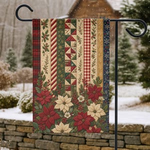 Könnte beinhalten: Eine rechteckige Gartenflagge an einem schwarzen Metallständer mit einem vertikalen Patchwork-Design aus roten, grünen und cremefarbenen Streifen sowie floralen Stechpalmen- und Weihnachtssternmustern am unteren Rand in Rot, Creme und Dunkelgrün.