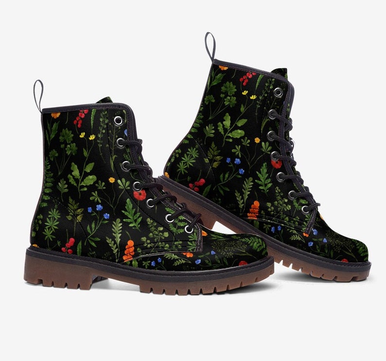 May include: Black lace-up boots with a floral pattern featuring green leaves, red berries, and blue and yellow flowers.
