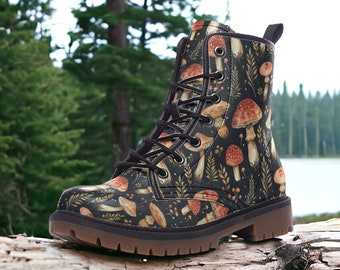May include: Black leather lace-up boots with a mushroom and foliage print. The boots have a brown sole and are sitting on a log.
