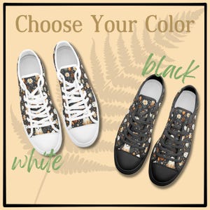 May include: Two pairs of low-top canvas shoes with a black and white ghost and floral pattern. The shoes are available in white or black.