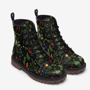 May include: Black leather ankle boots with a floral print featuring green leaves, red, yellow, and blue flowers. The boots have a lace-up closure and a chunky sole.