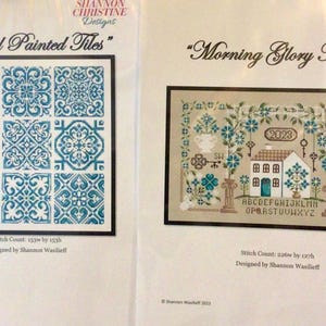 May include: Two cross-stitch patterns. One features nine teal and white tiles with a floral design, titled "Hand Painted Tiles." The other, "Morning Glory Manor," depicts a house, flowers, and keys.