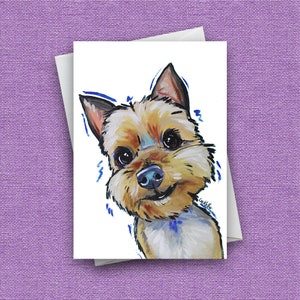 以下が含まれることがあります： 茶色と白の毛並みのヨークシャーテリアの犬の絵。犬は幸せそうな表情で鑑賞者を見つめている。絵は青色のアクセントがついたカラフルなスタイルで描かれている。