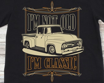 Op de afbeelding: Zwart T-shirt met een vintage-stijl afbeelding van een witte pick-up truck en de tekst "I'm not old I'm classic".