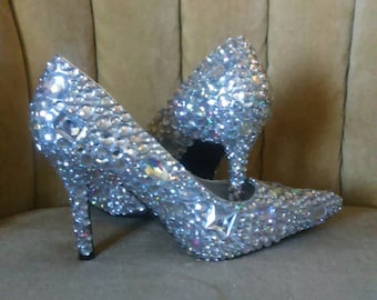 Könnte beinhalten: Ein Paar silberne High-Heel-Schuhe, die mit funkelnden Strasssteinen besetzt sind.