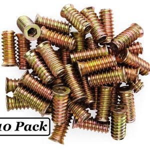 May include: A close-up of a pile of 10 gold-colored threaded inserts. The inserts are designed to be used in wood or other materials to create a threaded hole for a screw.