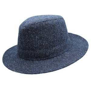Puede incluir: Un sombrero fedora de tweed azul con estampado de espiga y ala ancha.