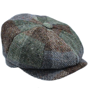 Peut inclure: Une casquette de newsboy en tweed vert, marron et bleu avec un bouton sur le dessus.