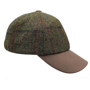 Puede incluir: Una gorra de béisbol de tweed verde y marrón con una visera de cuero marrón.