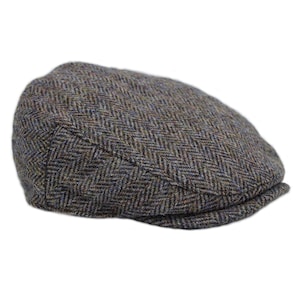 Puede incluir: Una gorra plana de tweed marrón y azul con un patrón de espiga.