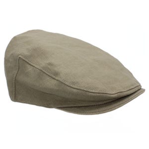 May include: A tan-colored, flat cap made of a textured fabric. The cap has a rounded crown and a small, stiff brim. The hat is a classic style, suitable for casual wear.