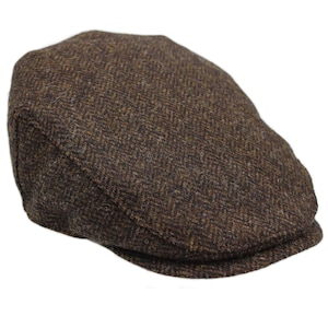 Può includere: Un berretto piatto in tweed marrone con un motivo a spina di pesce.