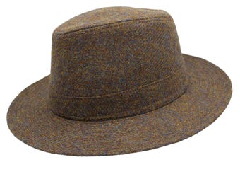 Könnte beinhalten: Ein brauner Tweed-Fedora-Hut mit breiter Krempe.
