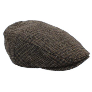 May include: A brown tweed flat cap. The cap features a classic design and is made from a textured fabric with a subtle pattern. A traditional style of hat, suitable for various occasions.