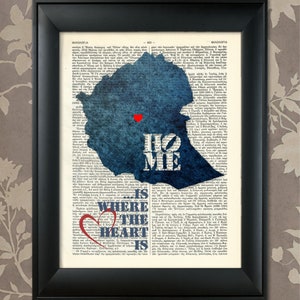 Puede incluir: Una silueta azul de Etiopía con las palabras "Home is where the heart is" y un corazón rojo en el centro del país. La imagen está impresa en una página de libro vintage.