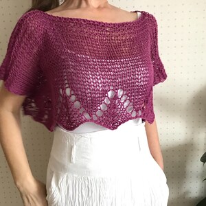 Puede incluir: Una blusa de ganchillo rosa con un dobladillo festoneado y mangas cortas.
