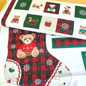 May include: A printed fabric panel featuring a Christmas stocking pattern with teddy bears in red and green jumpers, rocking horses, drums, and snowflakes. The design includes a red and green tartan background with white accents and holiday motifs.