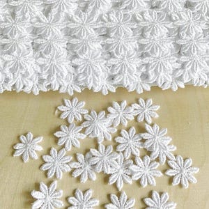 Broderad guipurespets 2,5 cm prästkragar/blommor. 30 stycken, vita. Påsydda lappapplikationer.