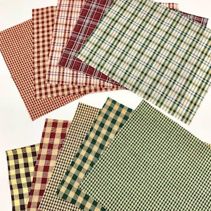 May include: A selection of fabric squares featuring diverse plaid and gingham patterns. The colours include red, green, yellow, and brown. The squares are arranged in a fan shape, displaying the different designs and colours.