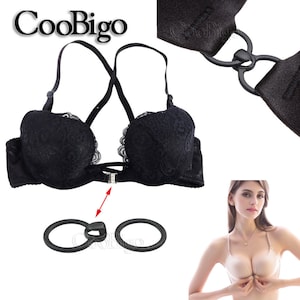 Könnte beinhalten: Schwarzer Spitzen-BH mit verstellbaren Trägern und Frontverschluss. Der BH hat ein Kreuzdesign im Rücken und wird mit zwei schwarzen Kunststoffringen zum Anpassen der Passform geliefert.